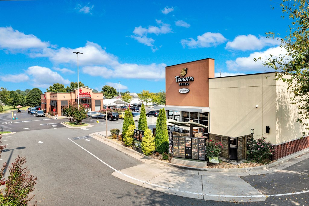 an empty parking lot in front of a building with a pizza restaurant