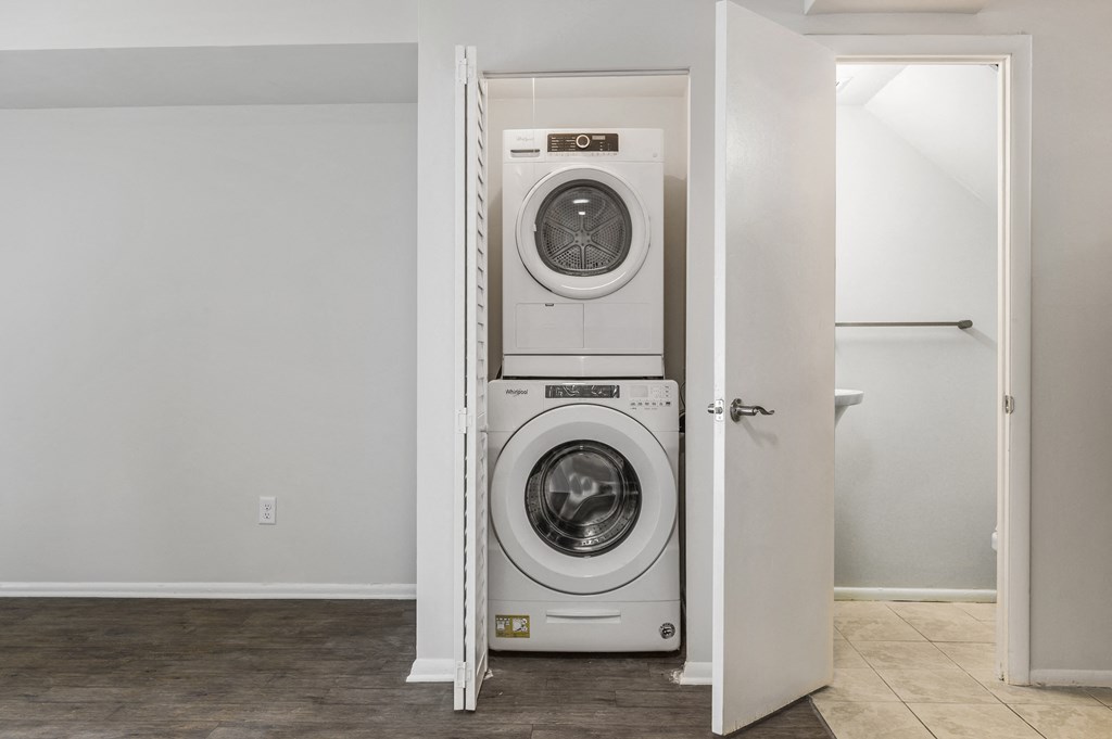 a front loading washer and dryer in a white closet