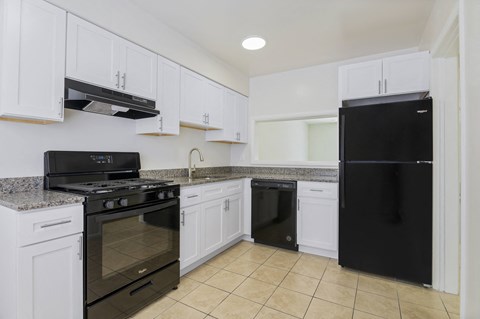 a kitchen with black appliances and white cabinets