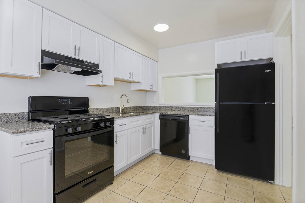 a kitchen with black appliances and white cabinets