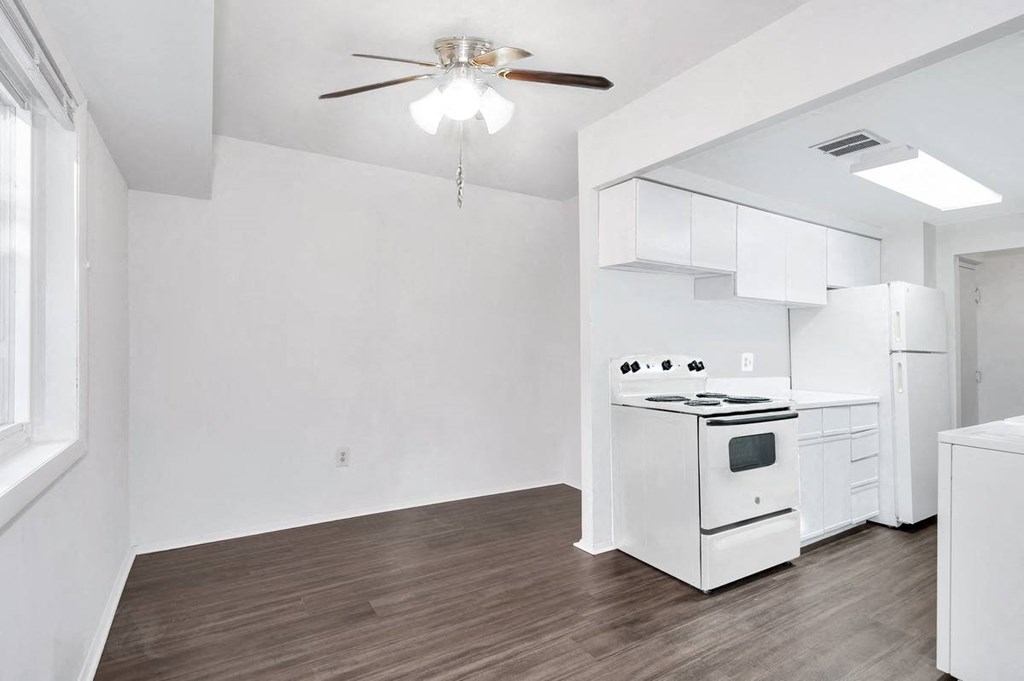 a kitchen with a stove a refrigerator and a ceiling fan