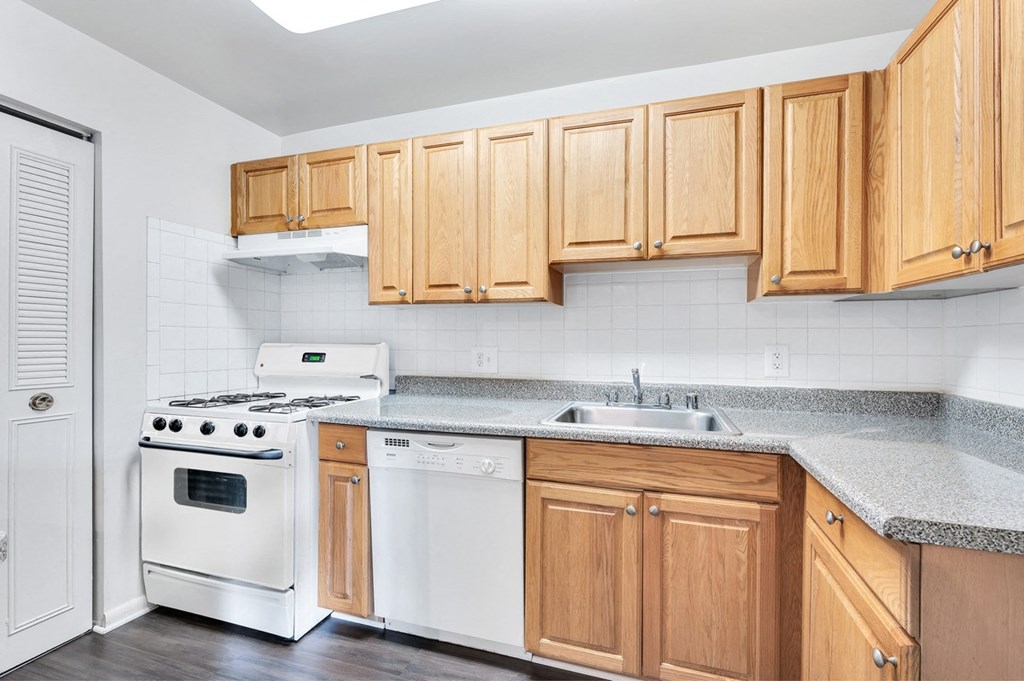 a kitchen with white appliances and wooden cabinets