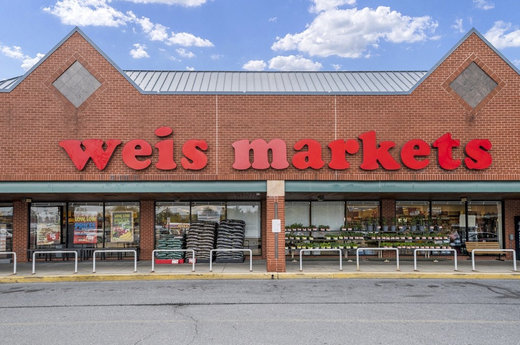 the front of a wells markets store with a red sign on the side of it