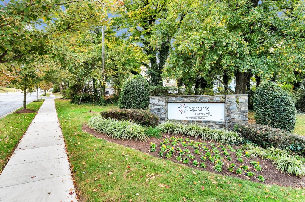 a sign in front of a building with trees in the background