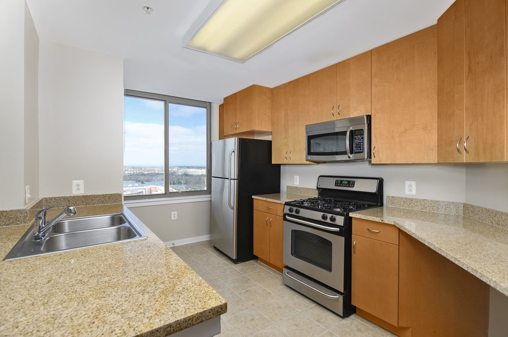 a kitchen with granite counter tops and stainless steel appliances and wooden cabinets