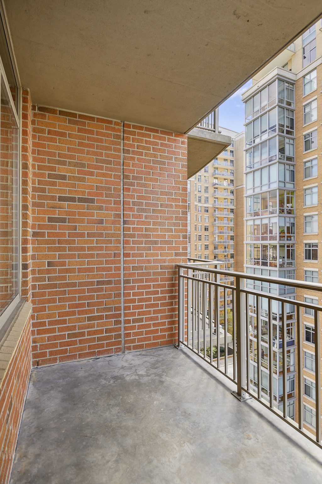a balcony with a view of a brick building and a concrete floor