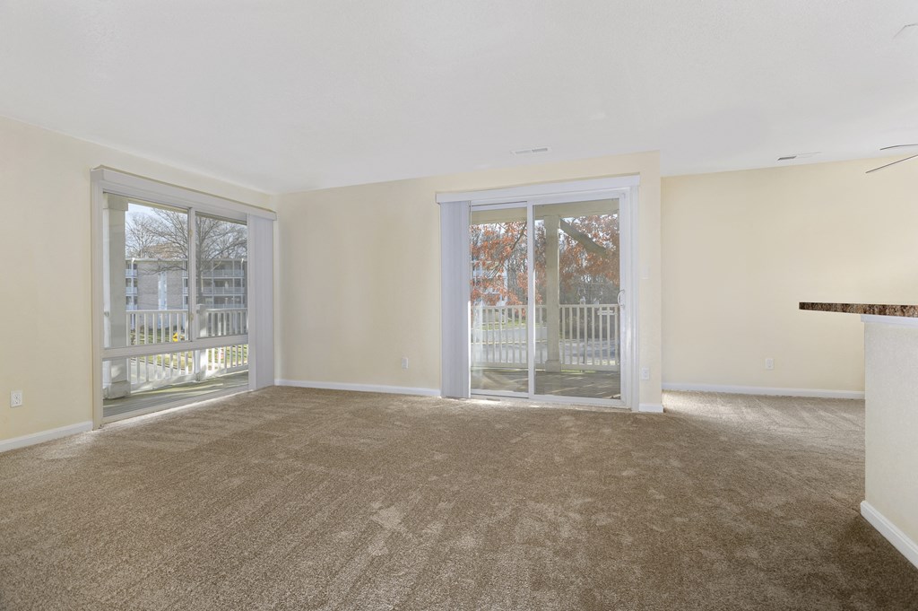 an empty living room with sliding glass doors to a balcony