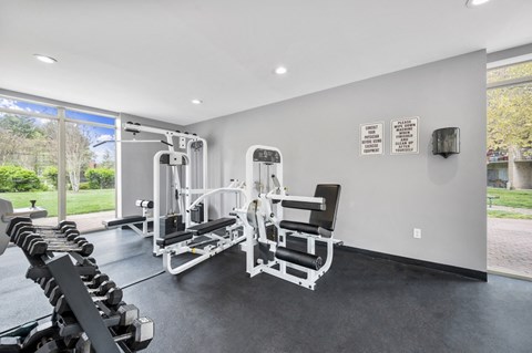 a gym with weights and cardio machines and a window