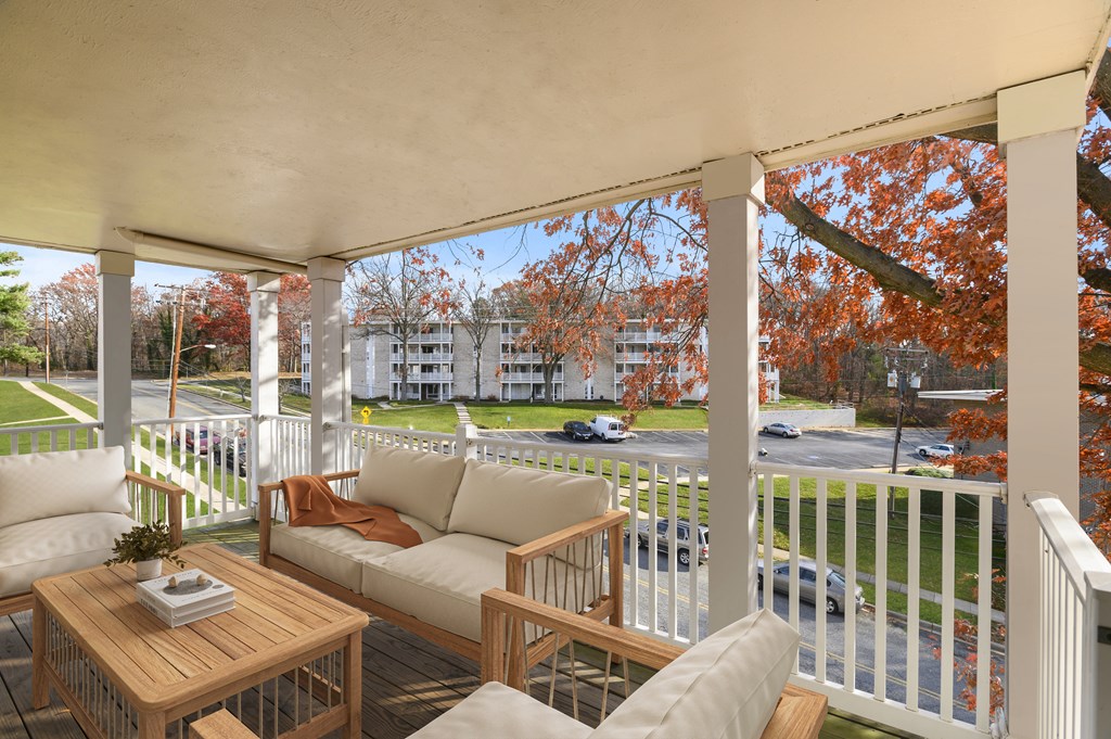A white porch with a table and chairs.