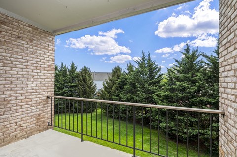 a balcony with a view of a yard and trees