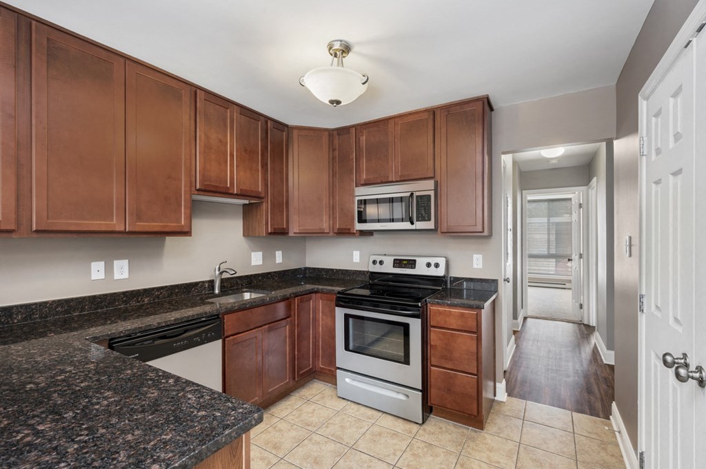 a kitchen with granite counter tops and wooden cabinets