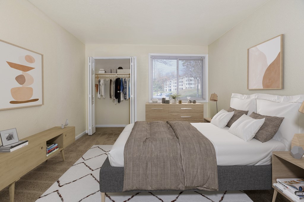 A bedroom with a large bed and a window overlooking a building.