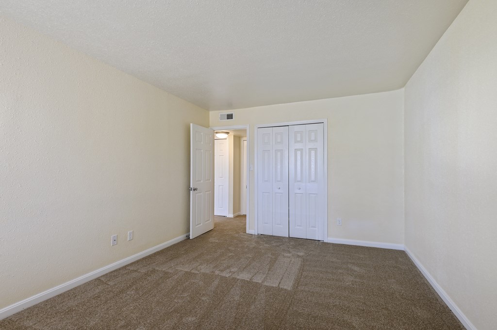 a spacious living room with carpeting and white walls
