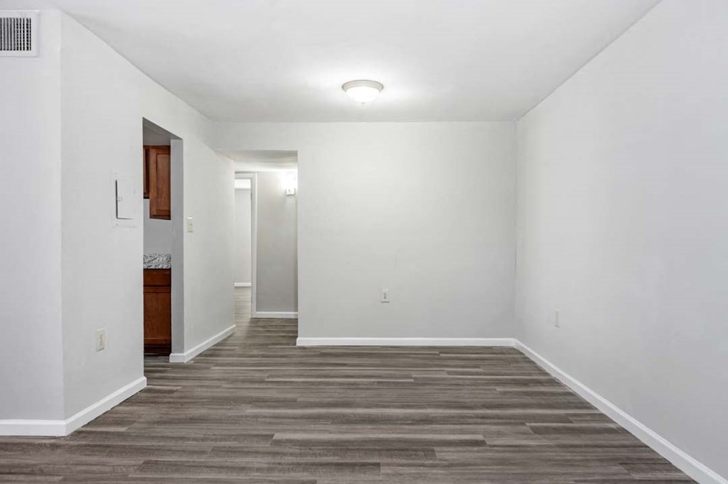 an empty living room with white walls and wood floors