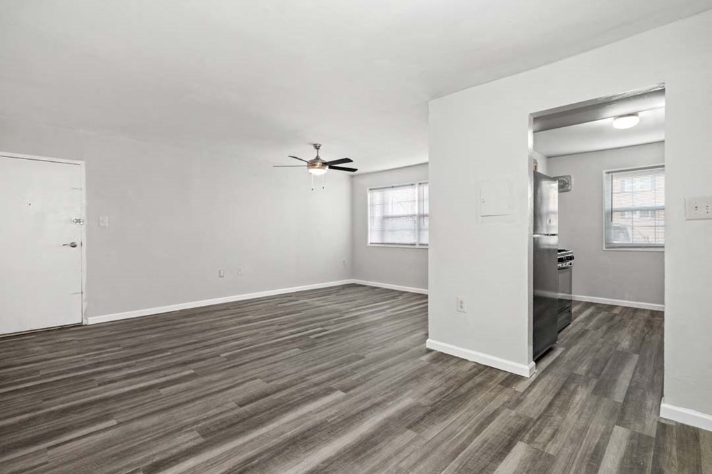 an empty living room with a ceiling fan