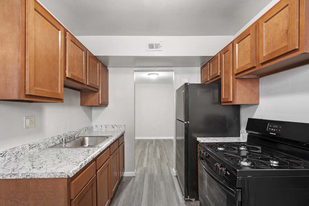 a kitchen with wood cabinets and a black stove and refrigerator