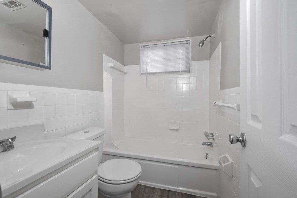 a white bathroom with a tub and a sink