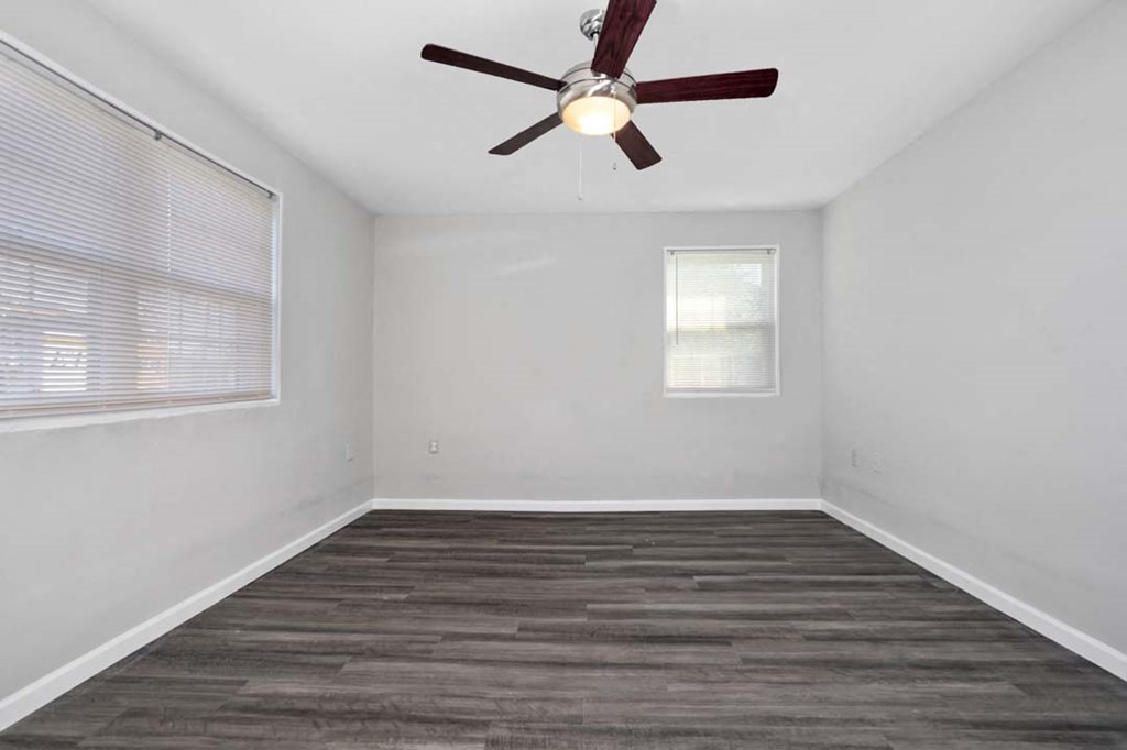 an empty room with a ceiling fan and a window