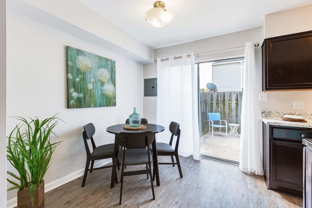 a dining area with a table and chairs and a sliding glass door
