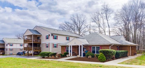 A large house with a red door and a balcony.
