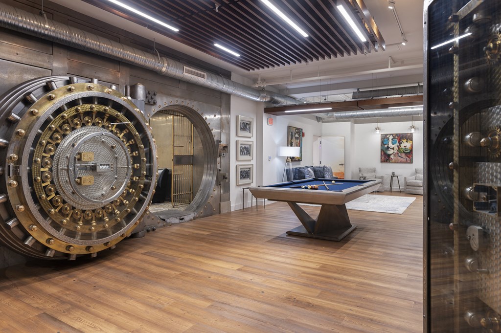 a room with a pool table and a rotating wheel on the wall