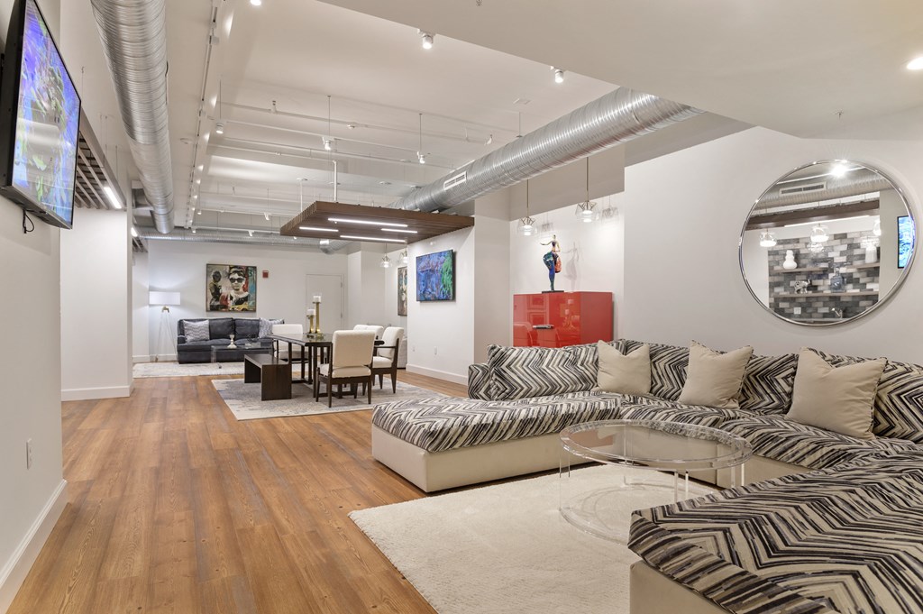 a living room with a couch and a table and a mirror