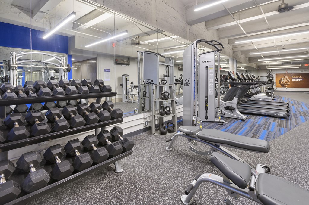 a view of the fitness center with weights and cardio equipment in the gym