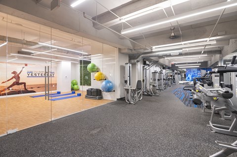 a gym with exercise equipment and mirrors on the wall