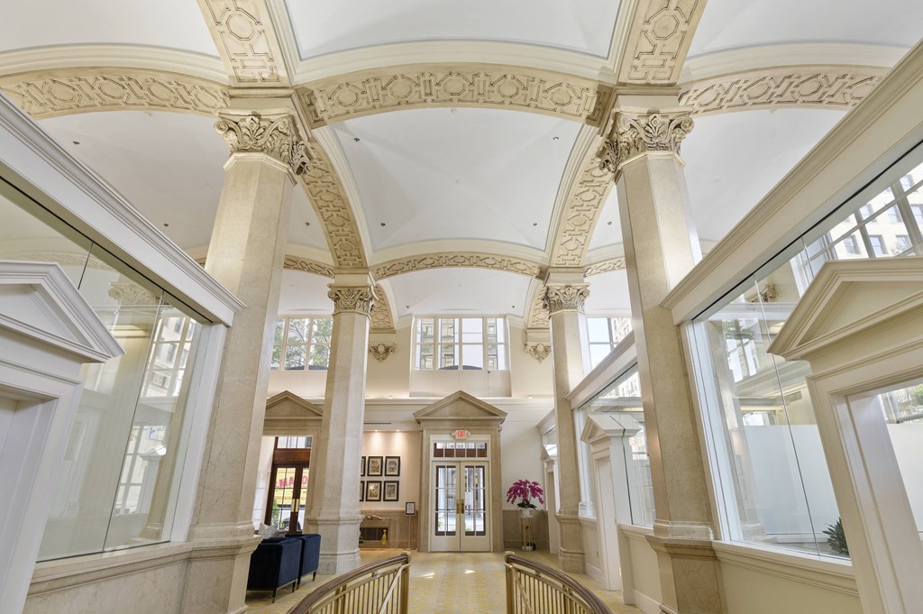 the lobby of a building with tall columns and a large ceiling