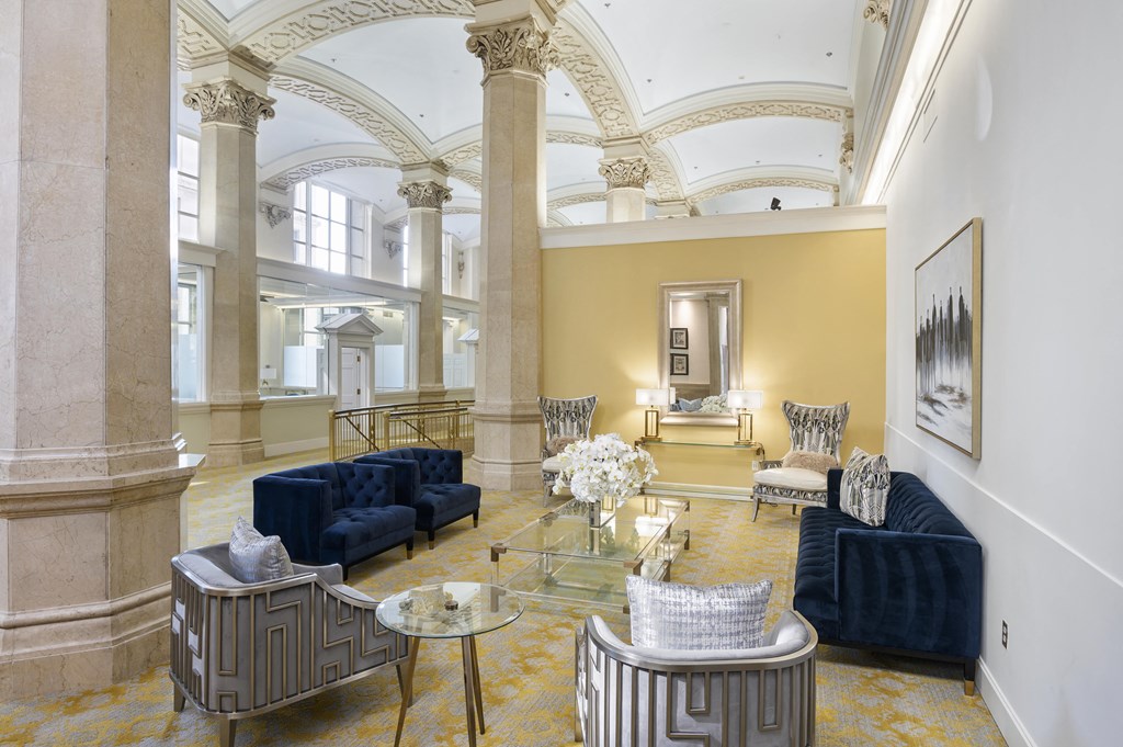 a living room with blue couches and a glass coffee table