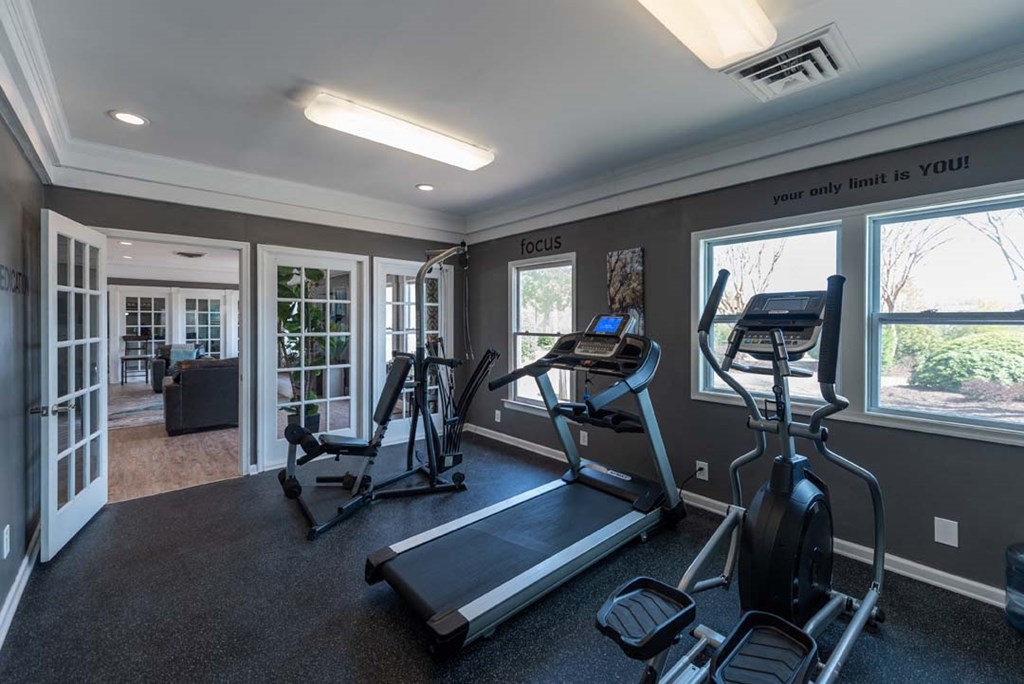 a home gym with exercise equipment and windows