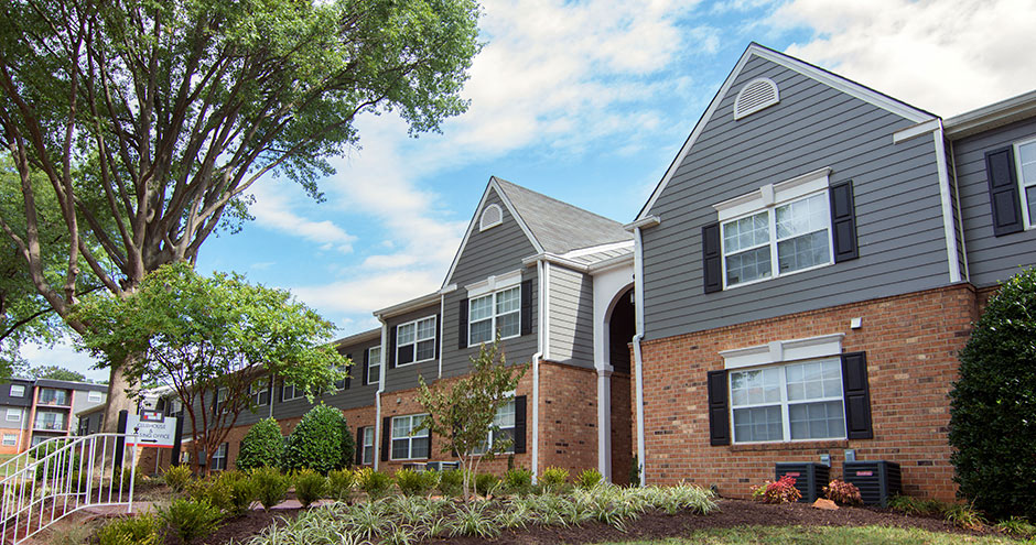 an apartment building with brick and gray roofs