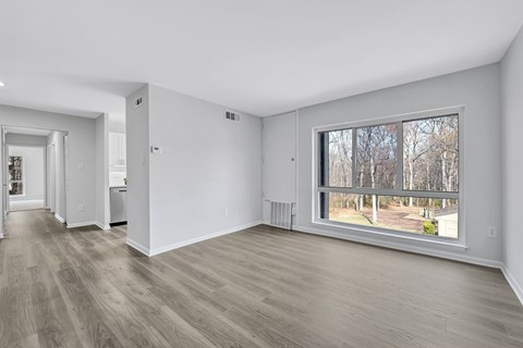 A room with a large window and a view of trees outside.