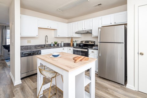 A kitchen with a table and chairs in the middle.
