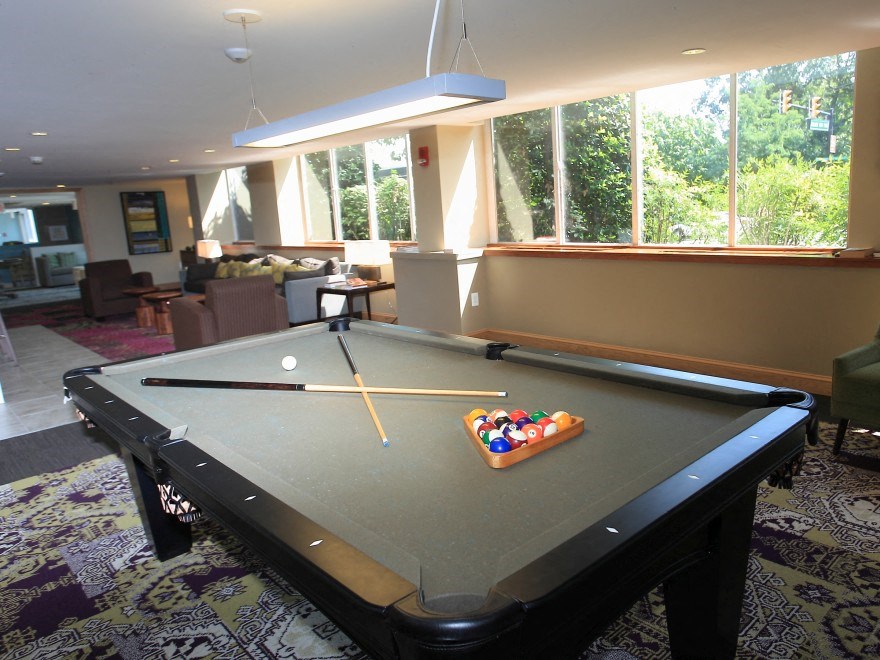 a pool table in a living room with a large window