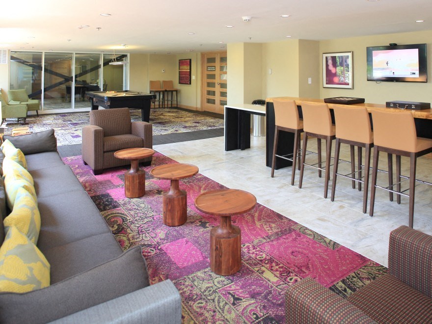 a living room with couches and a bar and a television