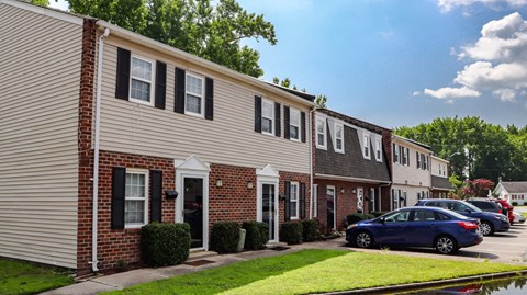 a row of townhomes with cars parked in front of them