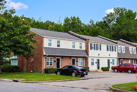 a row of houses with cars parked in front of them