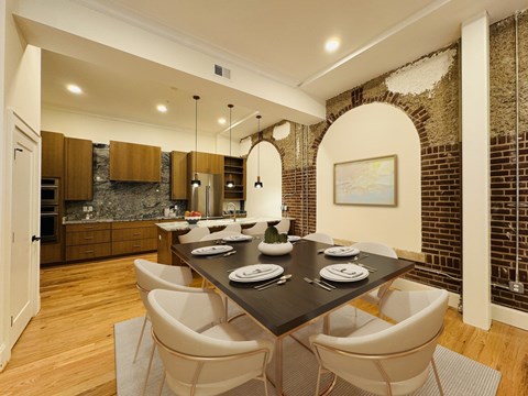 A dining room with a black table and white chairs.