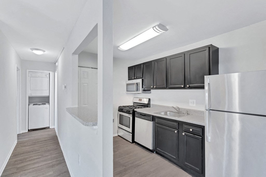 a kitchen with black cabinets and white appliances and a refrigerator
