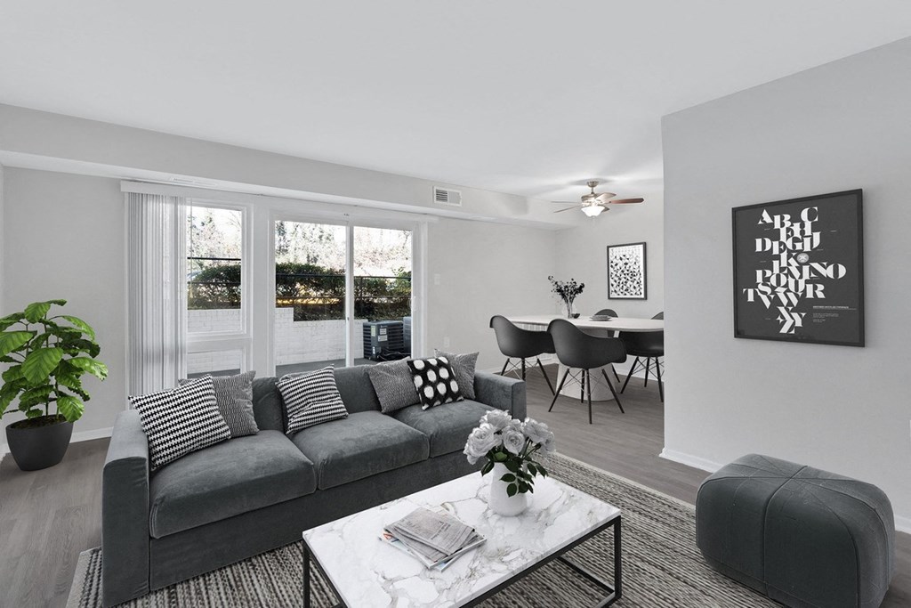 an open living room with a gray couch and a coffee table