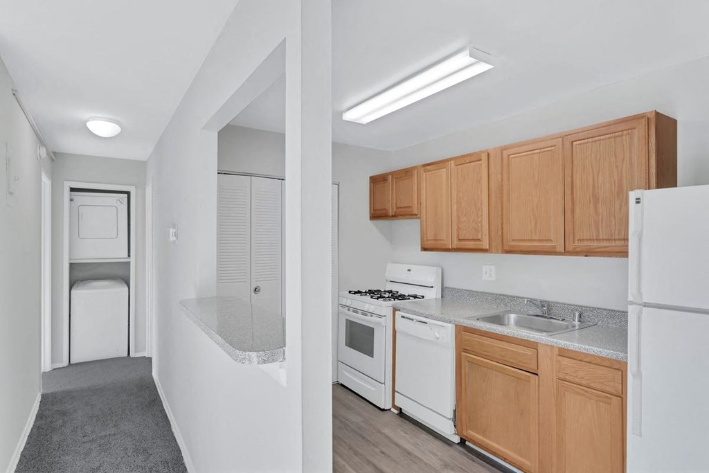 a kitchen with white appliances and wooden cabinets