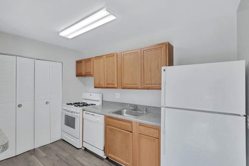 a kitchen with white appliances and wood cabinets