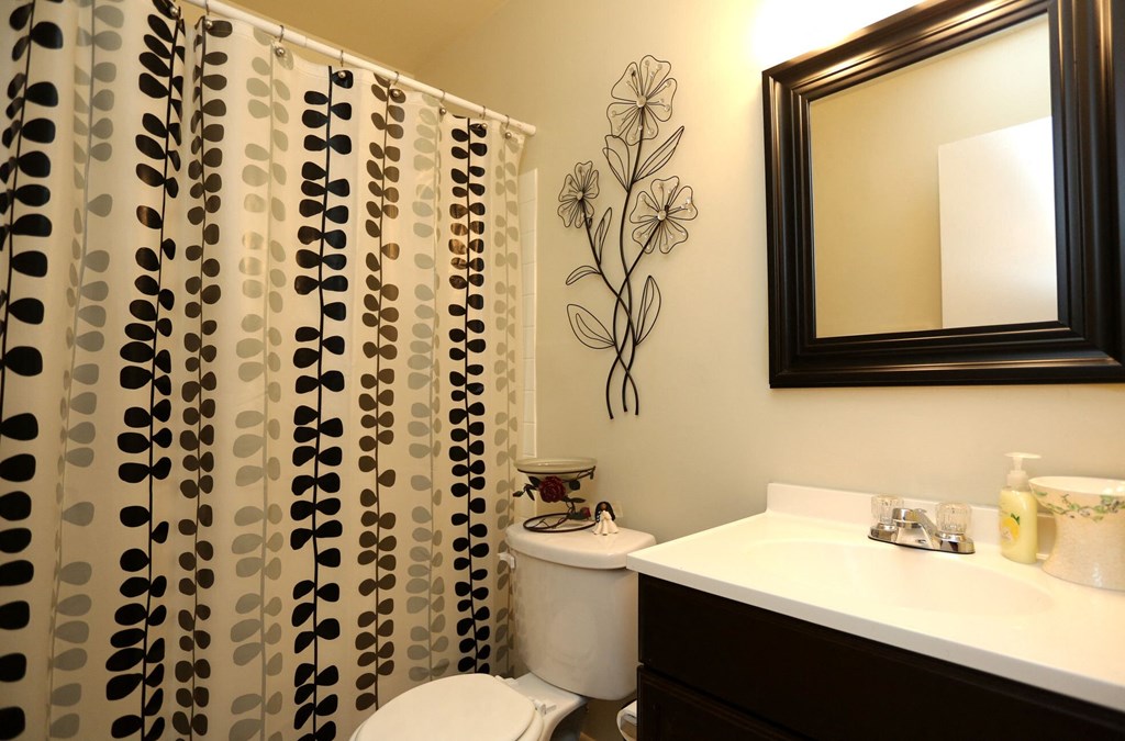 a bathroom with a shower curtain and a sink and a toilet