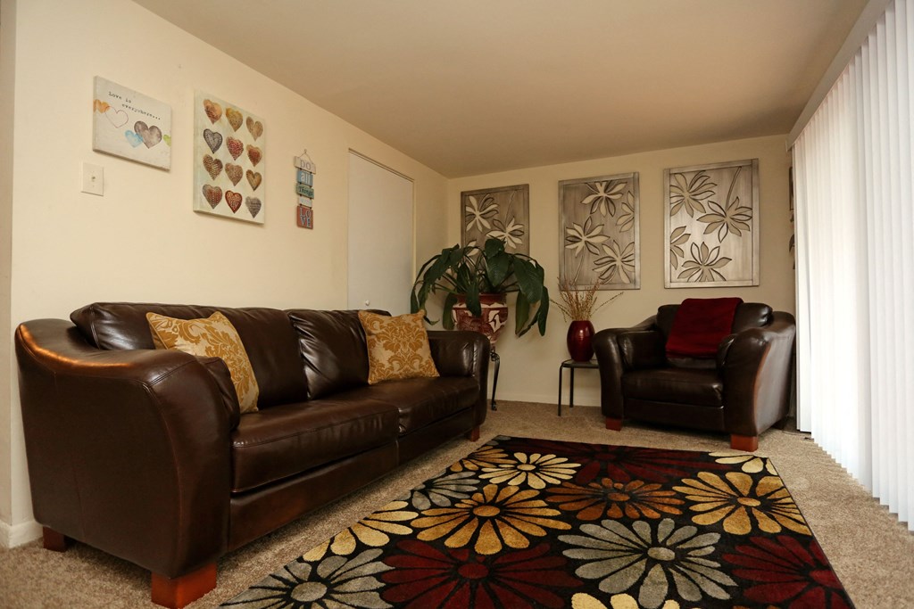 a living room with leather couches and a carpet