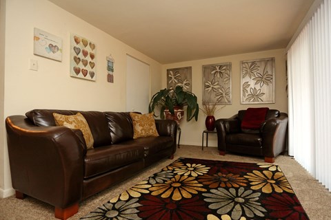 a living room with leather couches and a carpet