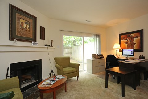 a living room with a fireplace and a desk with a computer