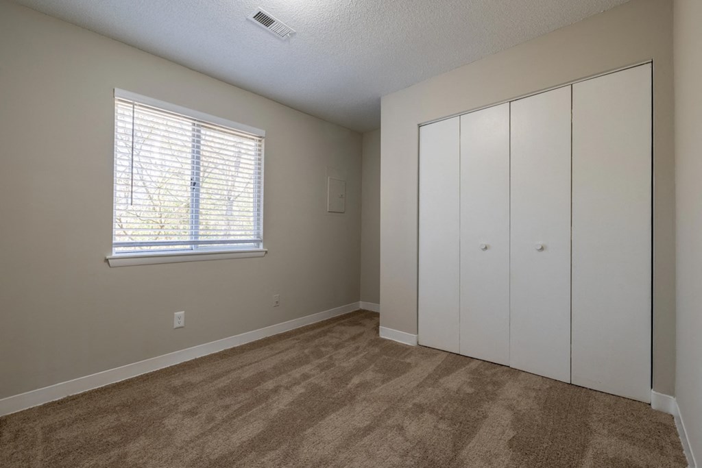 a bedroom with a closet and a window
