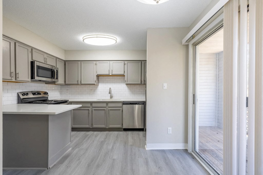 a renovated kitchen with stainless steel appliances and white cabinets