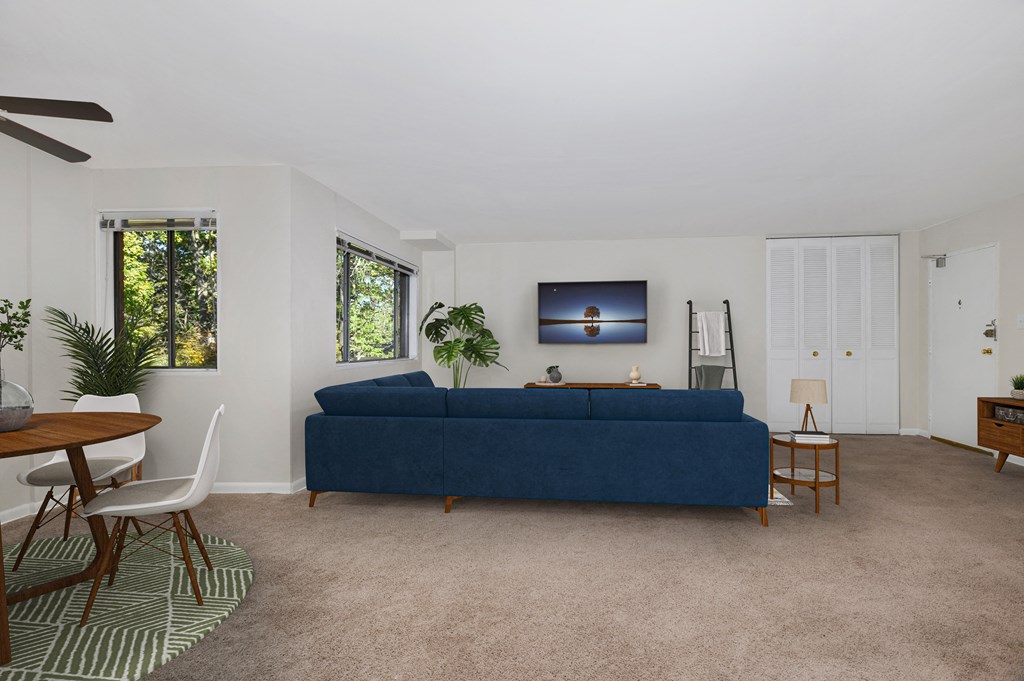 a living room with a blue couch and a dining room table
